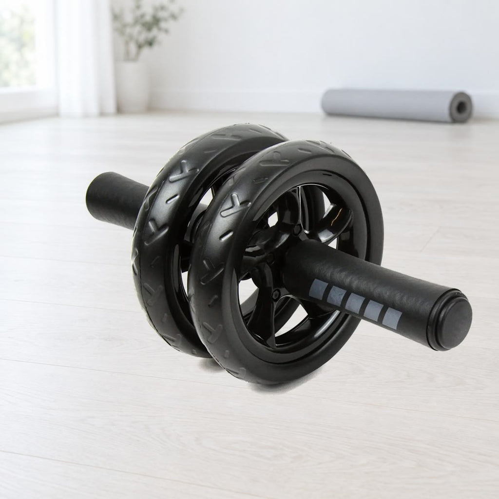 Ab wheel med to sorte, mønstrede hjul og skumhåndtag med grå striber på et lyst trægulv