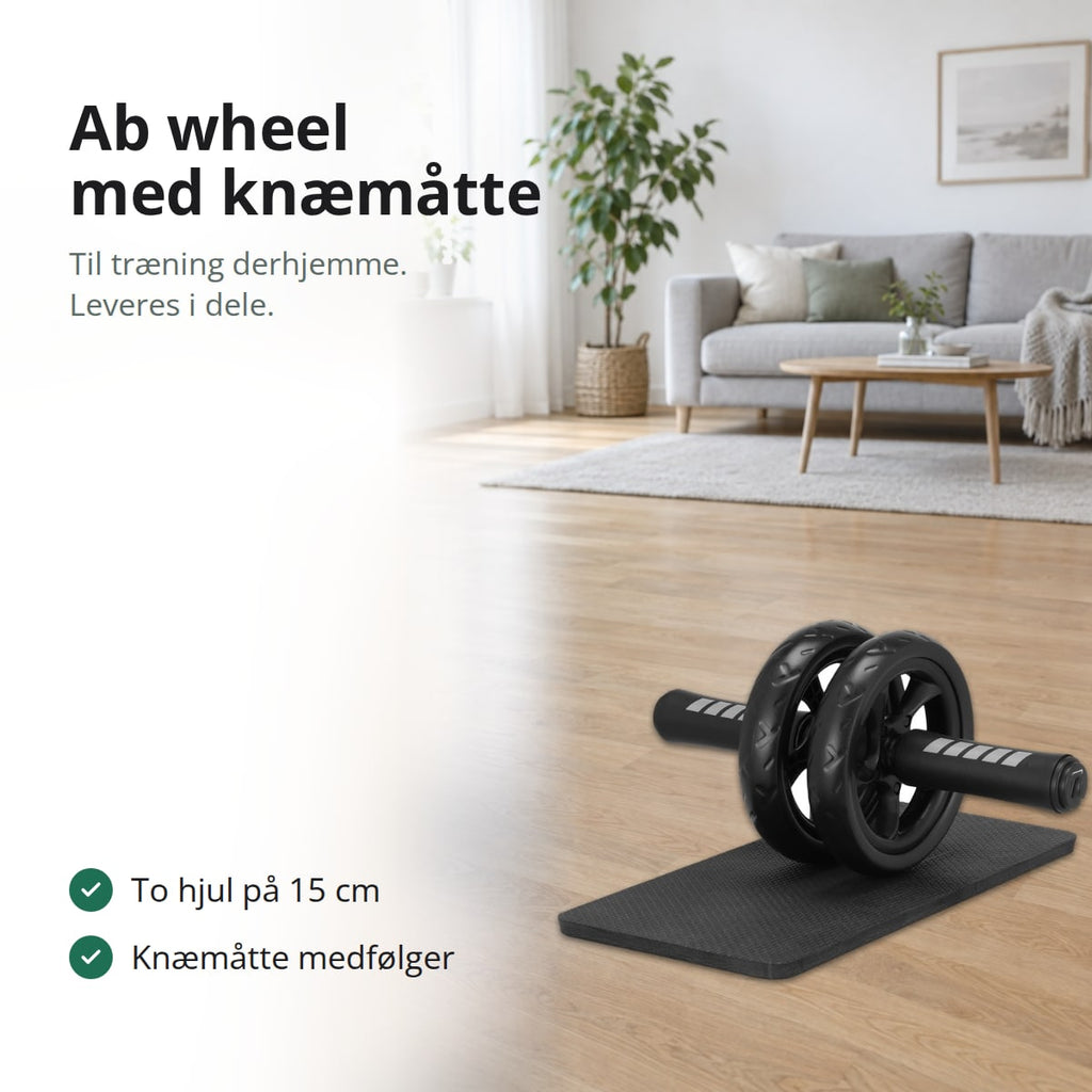 Ab wheel med to sorte hjul og skumgreb på en sort knæmåtte på parketgulvet i en lys dagligstue, med teksten: til træning derhjemme, leveres i dele, to hjul på 15 cm, knæmåtte medfølger