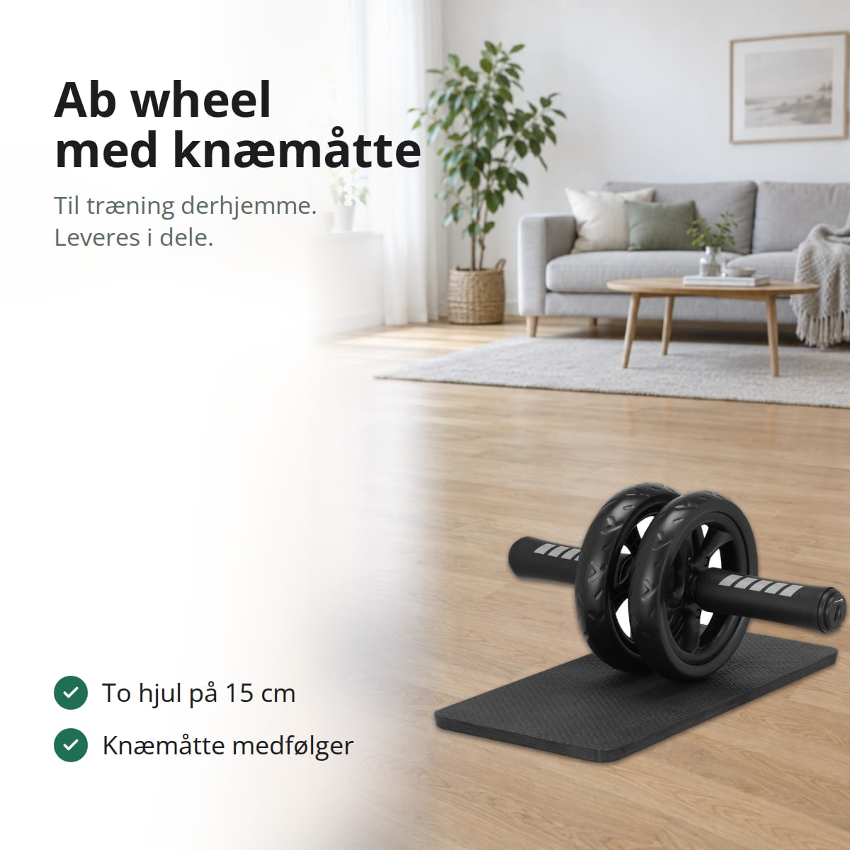Ab wheel med to sorte hjul og skumgreb på en sort knæmåtte på parketgulvet i en lys dagligstue, med teksten: til træning derhjemme, leveres i dele, to hjul på 15 cm, knæmåtte medfølger