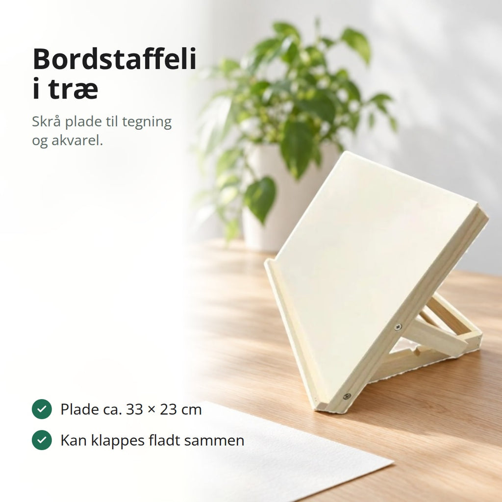Bordstaffeli i lyst, ubehandlet træ med skråtstillet plade på et egetræsbord ved et vindue, med teksten: skrå plade til tegning og akvarel, plade ca. 33 × 23 cm, kan klappes fladt sammen