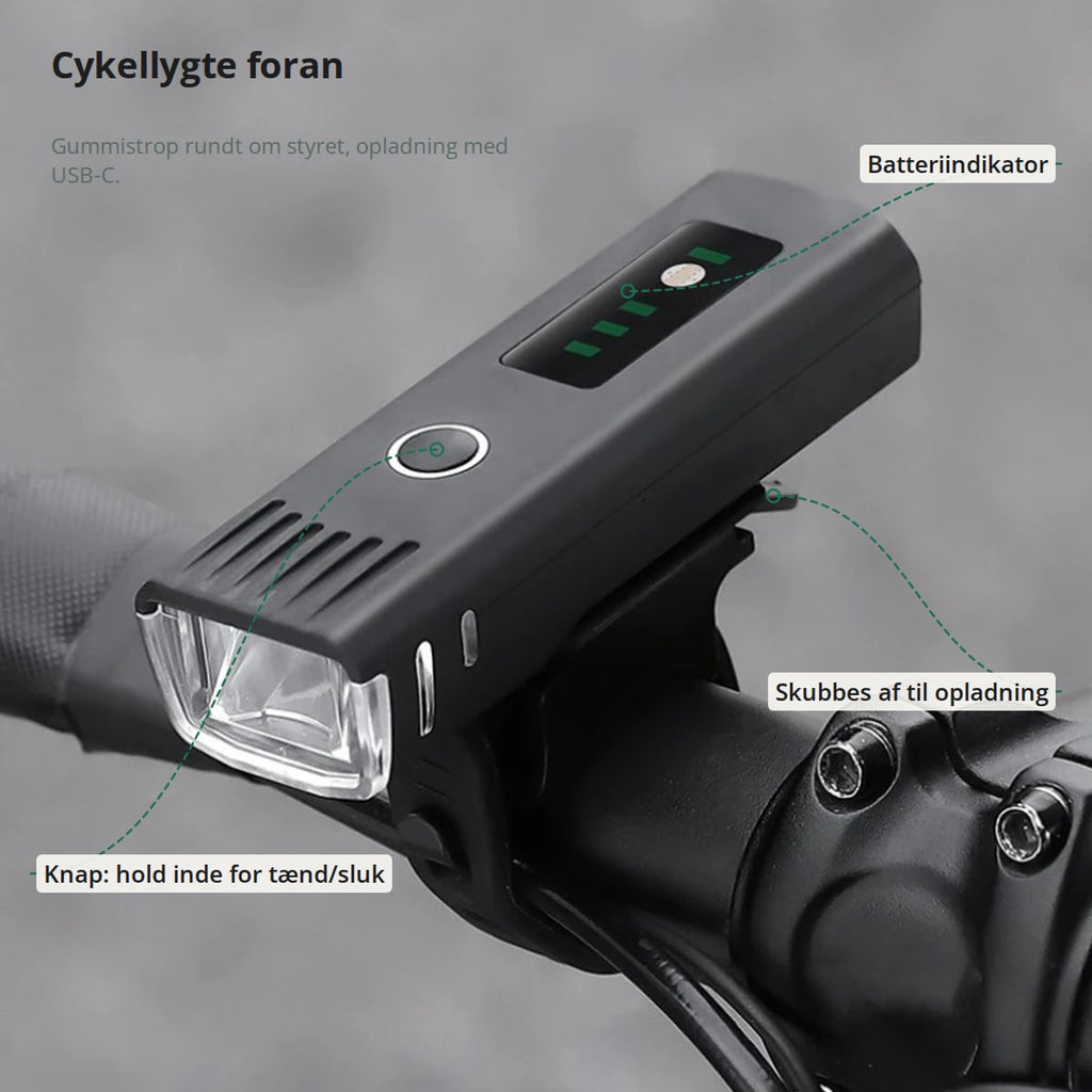 Cykellygte på styret med markeringer: knap, der holdes inde for tænd/sluk, batteriindikator og lygten, der skubbes af holderen til opladning