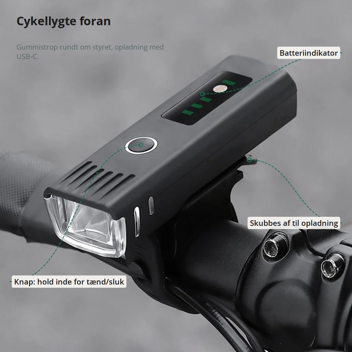 Cykellygte på styret med markeringer: knap, der holdes inde for tænd/sluk, batteriindikator og lygten, der skubbes af holderen til opladning