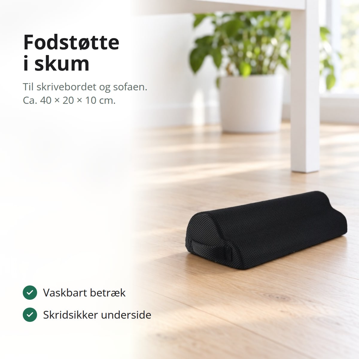 Sort fodstøtte i skum på et lyst trægulv under et skrivebord