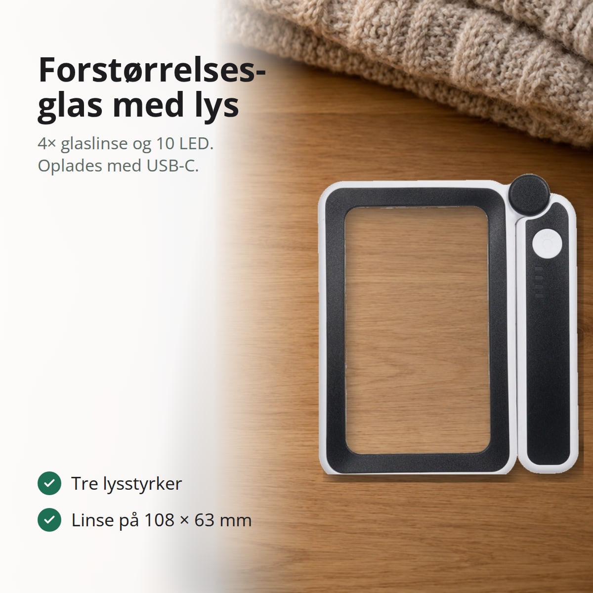 Rektangulært forstørrelsesglas med lys, der ligger på et træbord