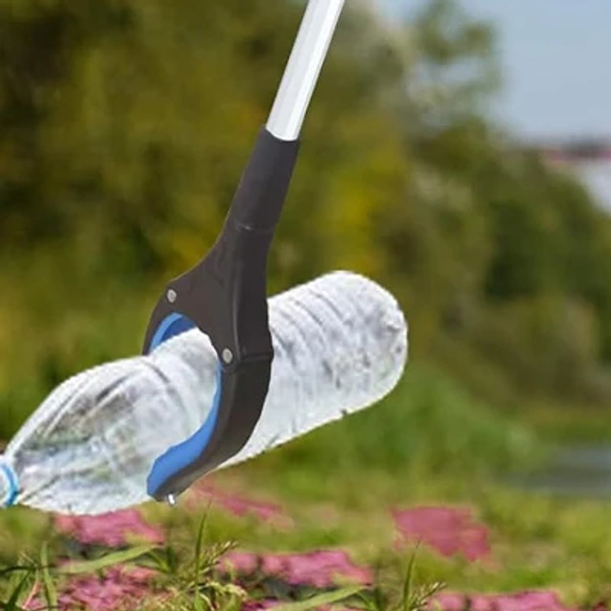 Gribetangen samler en tom plastflaske op fra græsset udenfor