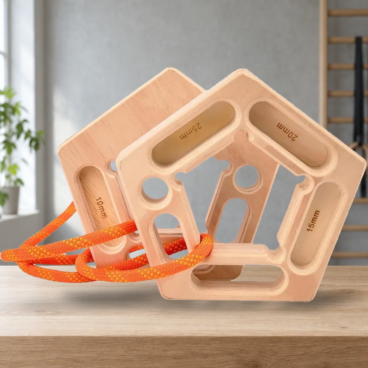 To femkantede hangboards med indgraverede kanter på 10, 15, 20 og 25 mm og et orange reb, stående på en bænk i et træningsrum