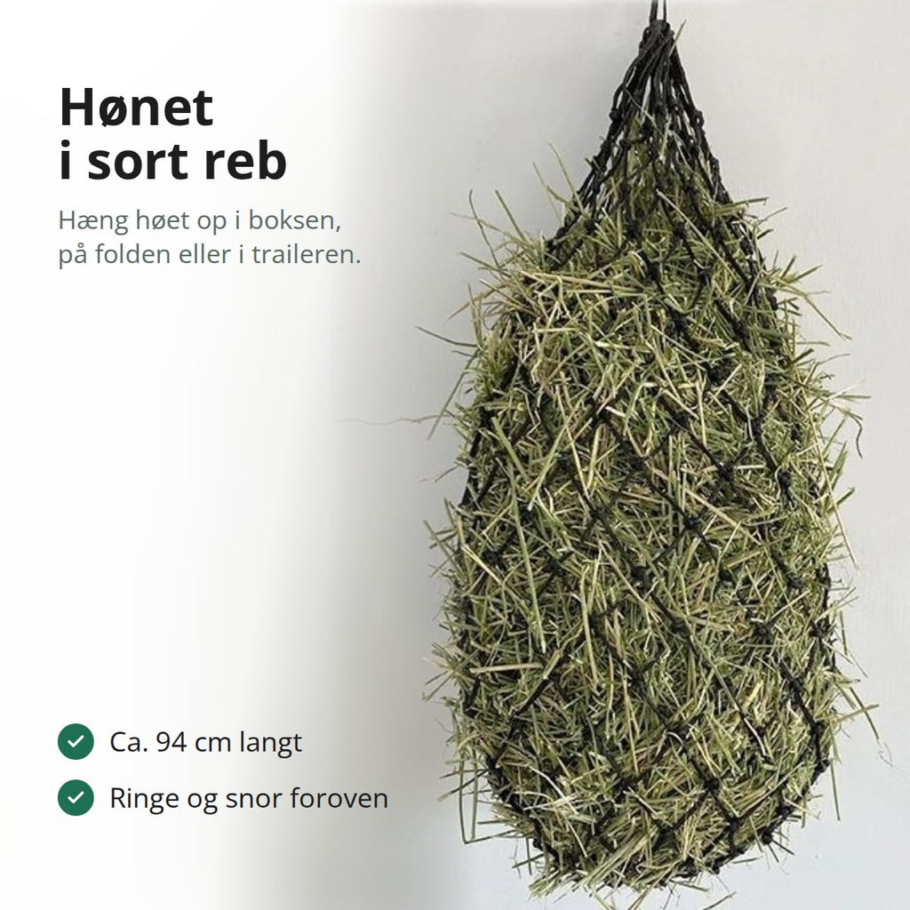 Sort hønet af knyttet reb, fyldt med hø og hængt op på en lys væg, med teksten: hæng høet op i boksen, på folden eller i traileren, ca. 94 cm langt, ringe og snor foroven