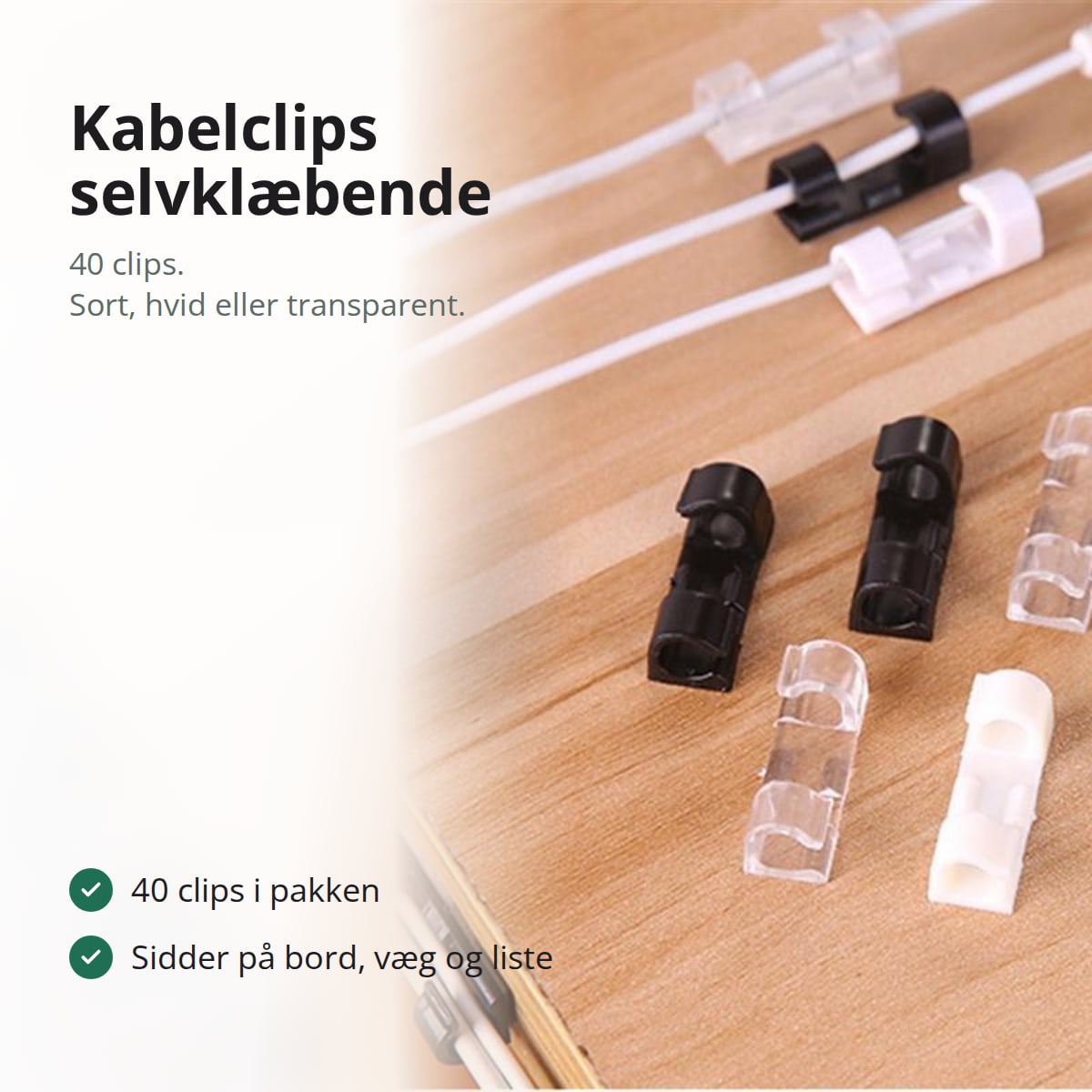 Sorte, hvide og transparente kabelclips på en bordkant med kabler, med teksten: 40 clips i pakken, sidder på bord, væg og liste