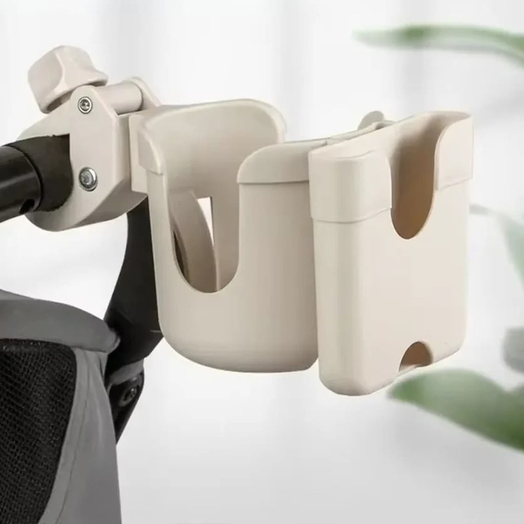 Beige kopholder med mobilholder spændt fast på håndtaget af en barnevogn