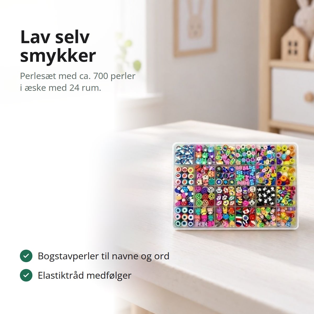 Perlesæt i en sorteringsæske med 24 rum på et hvidt skrivebord i et børneværelse, med teksten: lav selv smykker, perlesæt med ca. 700 perler i æske med 24 rum, bogstavperler til navne og ord, elastiktråd medfølger