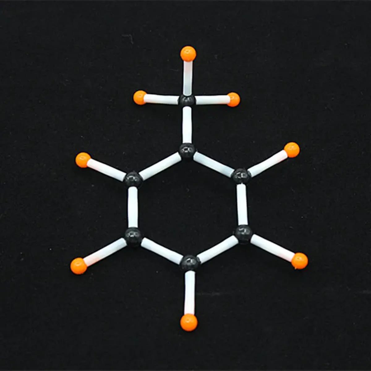 Seksring af sorte carbonatomer med orange hydrogenatomer og hvide plastrør, bygget med molekylebyggesættet