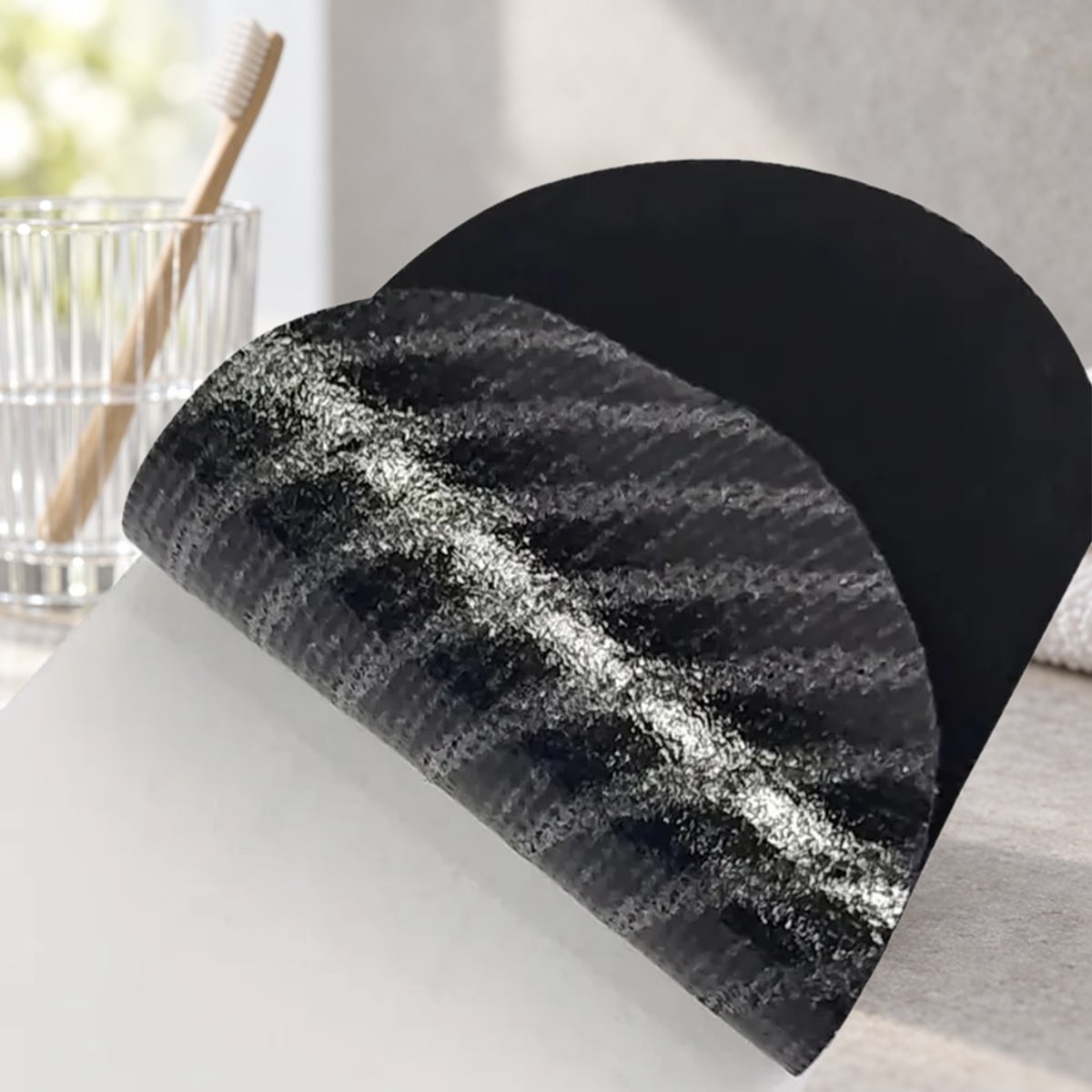 Strip mundtape på en hylde på badeværelset ved siden af et glas med en tandbørste