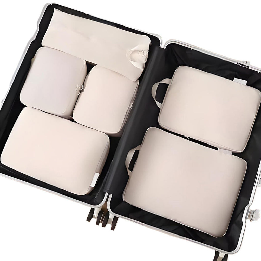 Packing cubes i sand: seks pakkeposer lagt fladt i en åben kuffert, set ovenfra