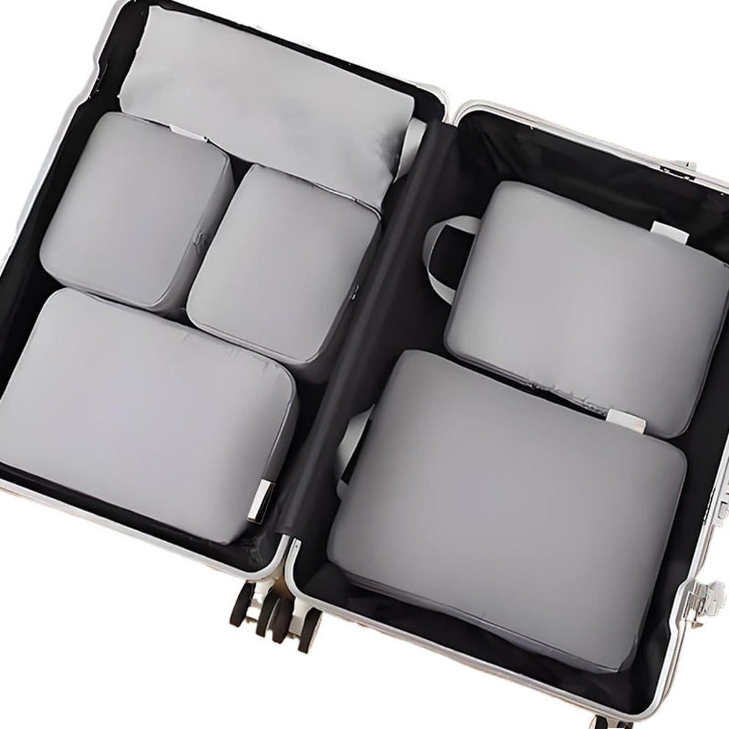 Packing cubes i blå: seks pakkeposer lagt fladt i en åben kuffert, set ovenfra