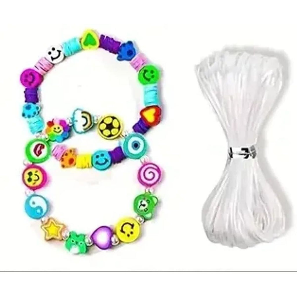 To armbånd lavet af lerperler med smileyer og motiver ved siden af en rulle elastiktråd