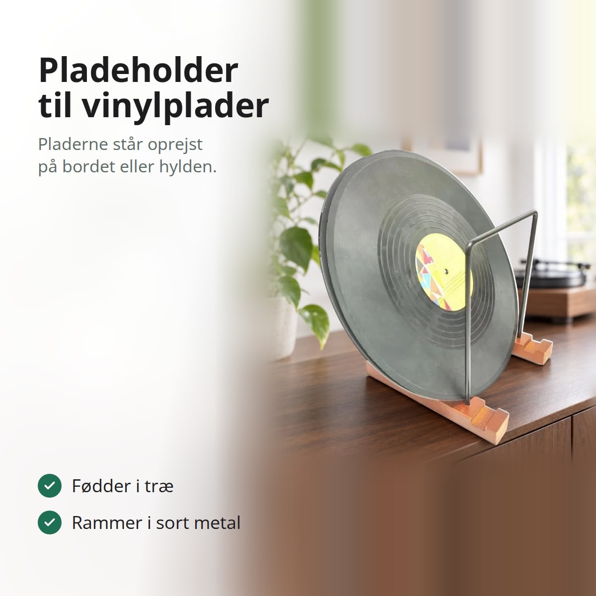 Pladeholder med fødder i træ og rammer i sort metal med en vinylplade på en skænk i valnød, med teksten: pladeholder til vinylplader, pladerne står oprejst på bordet eller hylden; fødder i træ, rammer i sort metal