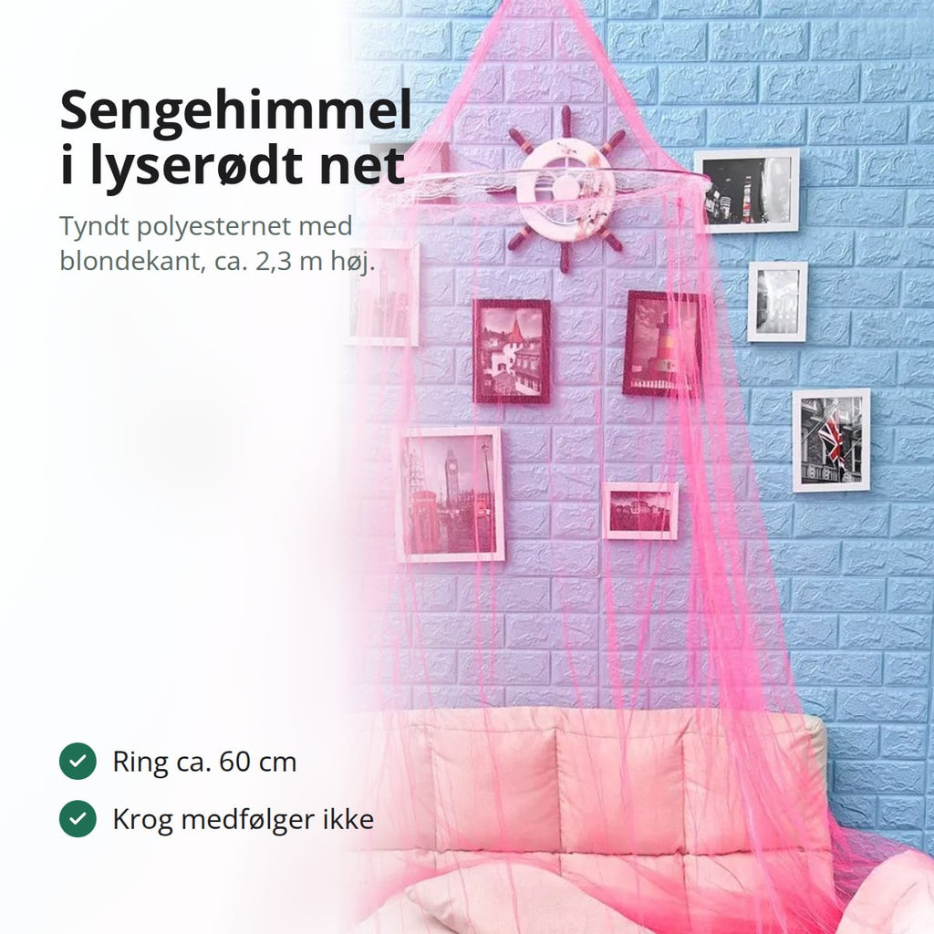 Lyserød sengehimmel i tyndt net hængt op over en lyserød sofa foran en lyseblå murstensvæg med billeder