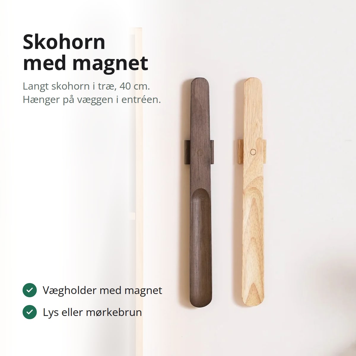 Skohorn med magnet i træ i mørkebrun og lys udgave, hængt på hver sin vægholder på en hvid væg
