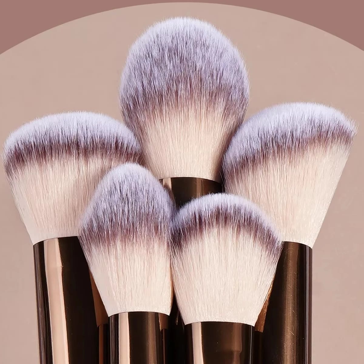Nærbillede af bløde syntetiske hår på fem store makeup børster