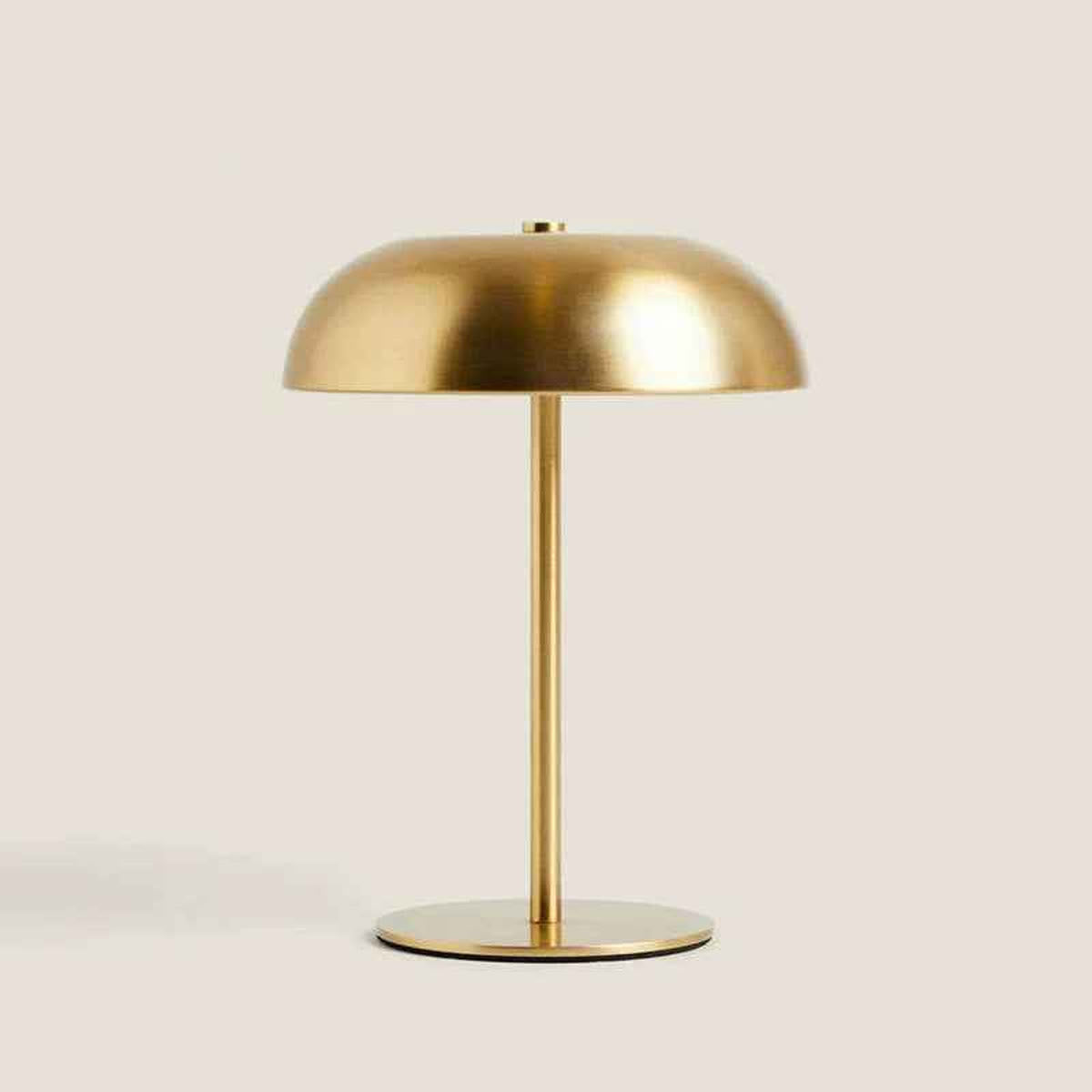 Mushroom lampe i guld på en beige baggrund