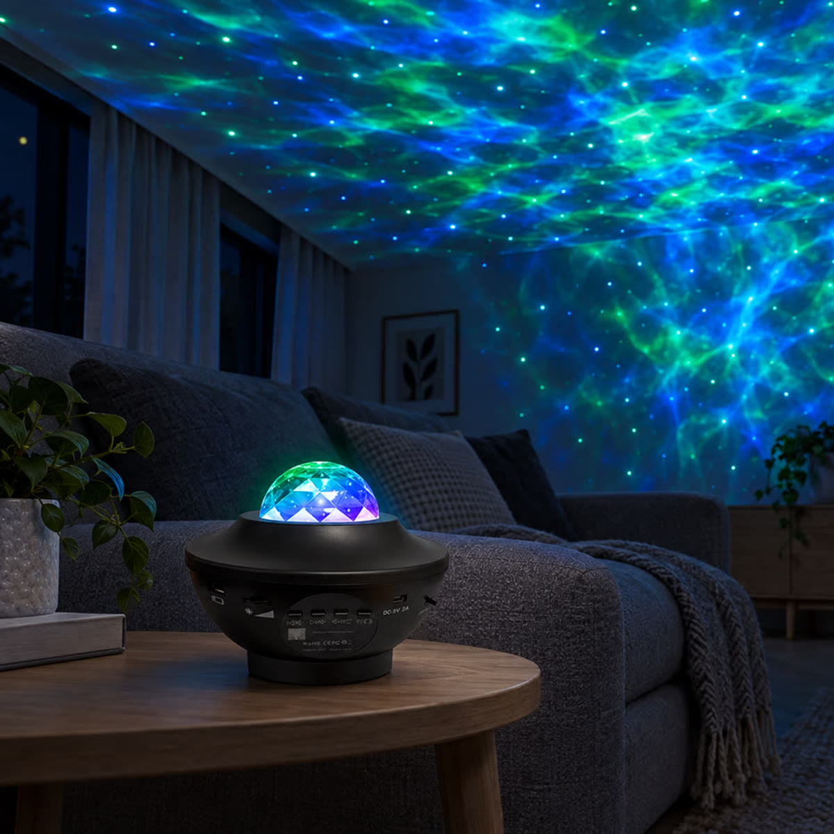 Stjernehimmel-projektor på et sidebord i en stue om aftenen, grønt og blåt lys på loftet