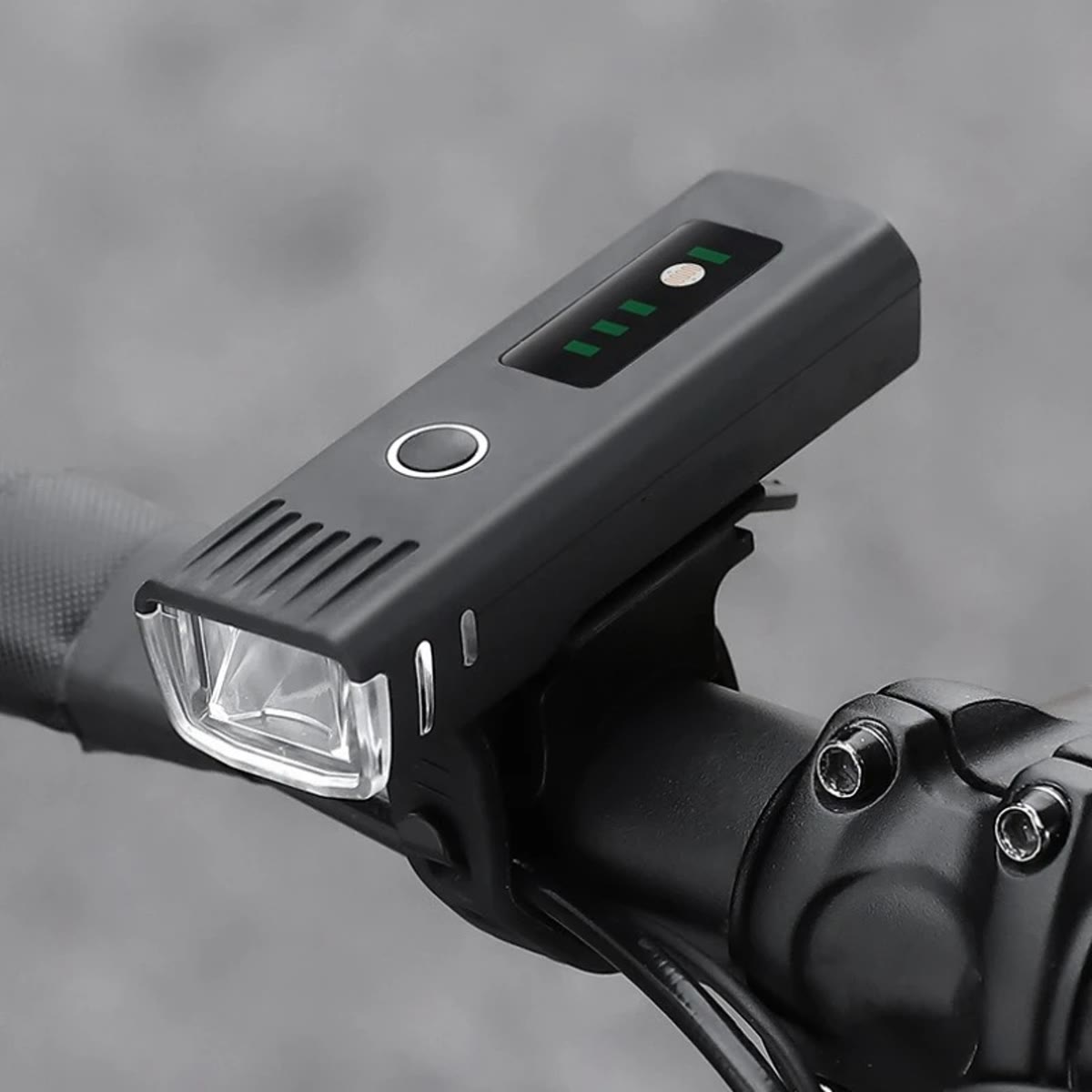 Cykellygte foran monteret på styret, med batteriindikator og knap på toppen
