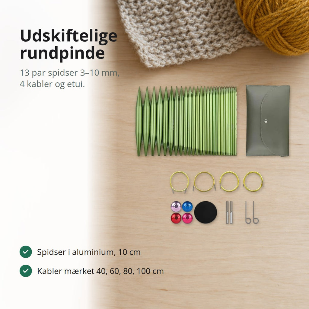 Udskiftelige rundpinde sæt i grøn aluminium med fire kabler, endestoppere, nøgler og etui på et lyst bord, med teksten: udskiftelige rundpinde, 13 par spidser 3–10 mm, 4 kabler og etui, spidser i aluminium 10 cm, kabler mærket 40, 60, 80 og 100 cm