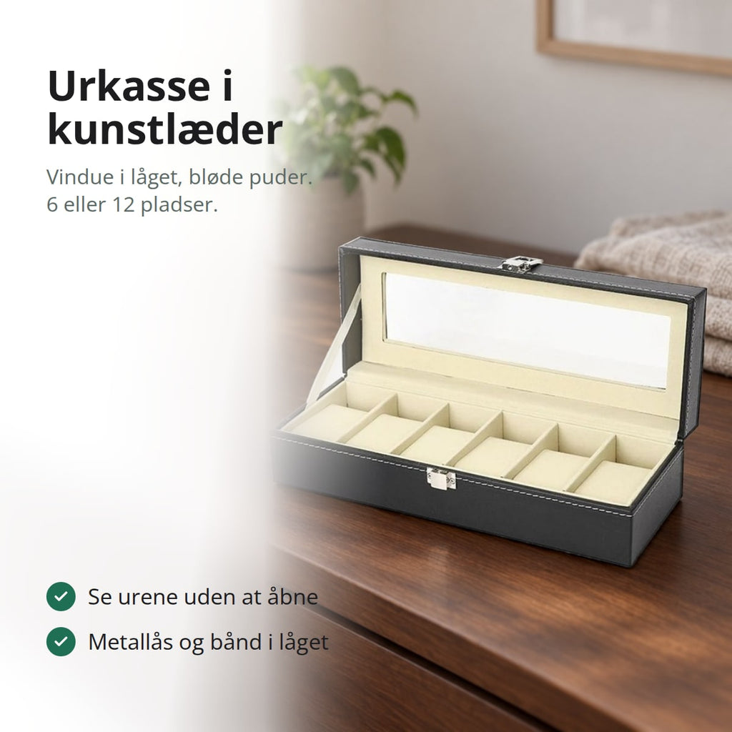 Urkasse i sort kunstlæder med seks puder og vindue i låget på en kommode
