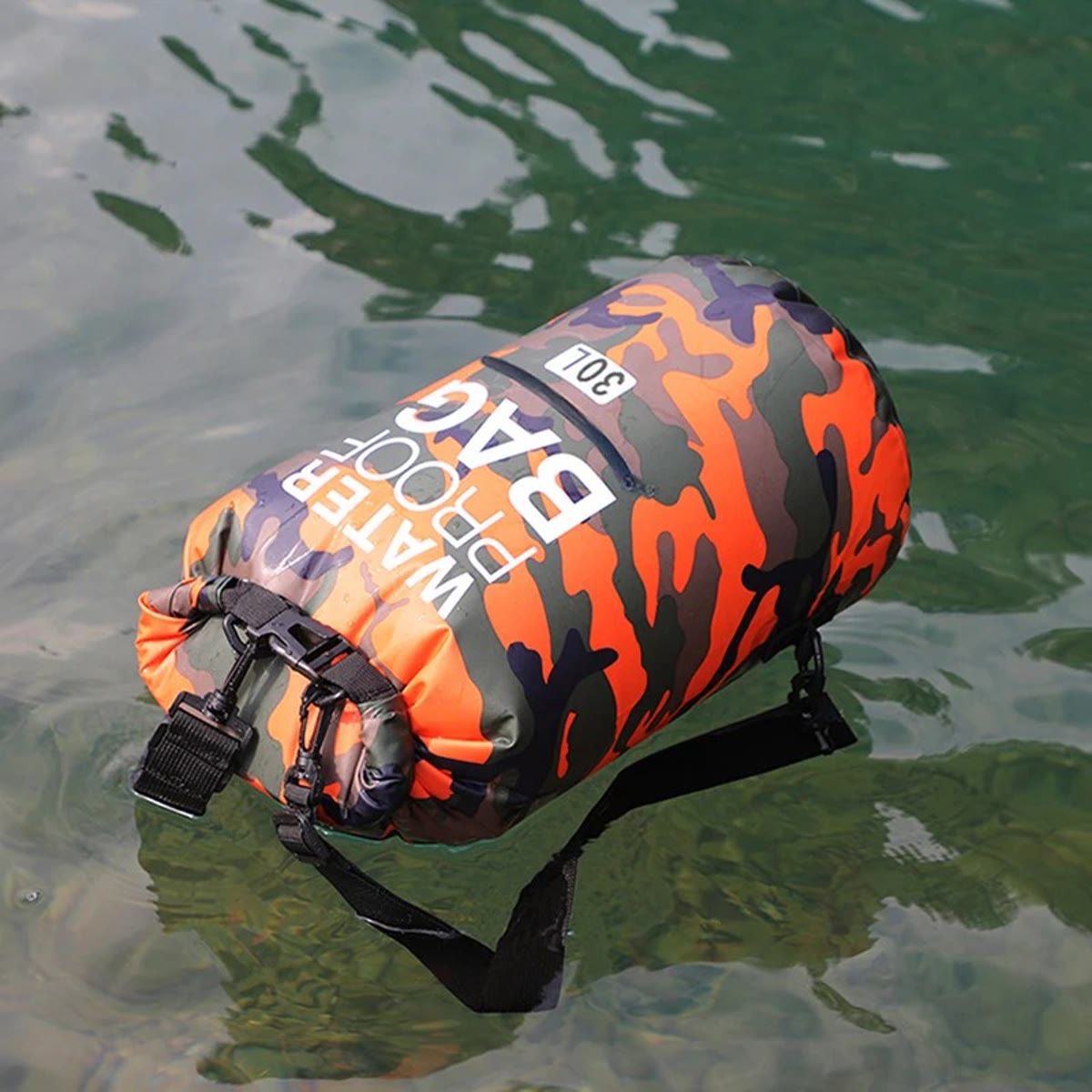 Vandtæt rygsæk i orange camouflage, der flyder på vandet med rulletoppen lukket
